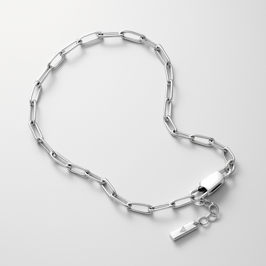Silver chain bracelet with a tag on a light gray background